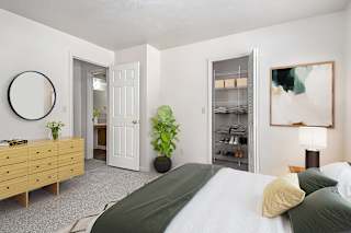 A bedroom with a bed, dresser, and a walk-in closet at North Pointe Apartments, Elkhart, IN, 46514