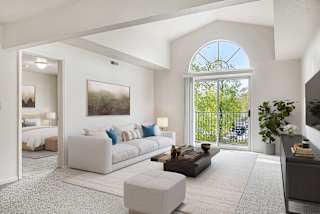 A living room with a cathedral ceiling and a half round window at North Pointe Apartments, Elkhart, IN, 46514