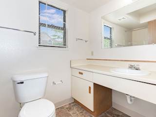 a bathroom with a toilet sink and a mirror  at Oak Shores Apartments, Oak Creek, WI, 53154