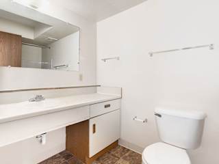 a bathroom with a toilet sink and a mirror  at Oak Shores Apartments, Oak Creek, 53154