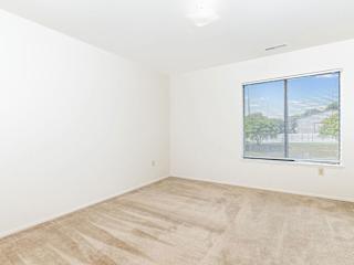 an empty room with a window and white walls  at Oak Shores Apartments, Oak Creek, 53154