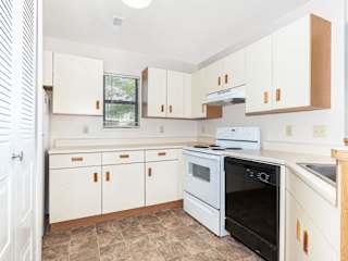 a kitchen with white cabinets and a stove and a oven  at Oak Shores Apartments, Oak Creek, Wisconsin