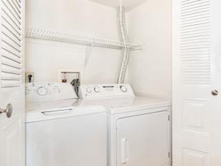 a white washer and dryer in a laundry room with a white closet  at Oak Shores Apartments, Oak Creek, WI, 53154