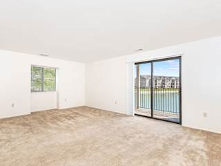 an empty living room with a sliding glass door to a balcony  at Oak Shores Apartments, Oak Creek, WI