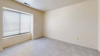an empty bedroom with a large window and carpeting  at Oak Shores Apartments, Oak Creek, 53154
