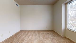an empty room with a large window and carpeting at Pine Knoll Apartments, Battle Creek, 49014