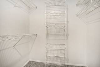 A walk-in closet with white organizers at Pine Knoll Apartments, Battle Creek, 49014