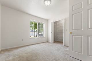 a bedroom with a closet and a large window at Hunters Pond Apartment Homes, Illinois, 61820
