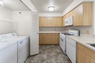 a kitchen with white appliances and wooden cabinets  at Hunters Pond Apartment Homes, Champaign