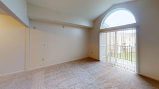 a living room with a large window and a door to a balcony at Hunters Pond Apartment Homes, Illinois, 61820