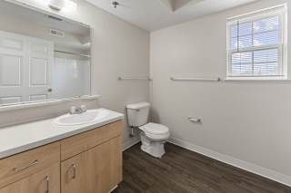 a bathroom with a window and a sink and a mirror  at Hunters Pond Apartment Homes, Champaign, 61820