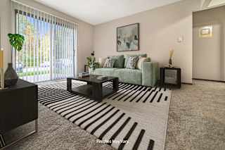 a living room with a couch and a coffee table in front of a sliding glass door at Timberlane Apartments, Peoria, 61615