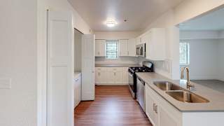 an empty kitchen with white cabinets and a sink at Green Ridge Apartments, Michigan, 49544