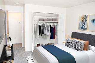 a bedroom with a closet full of clothes at Seville Apartments, Kalamazoo, MI, 49009