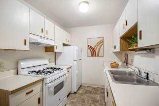 a kitchen with a stove refrigerator and sink at Seville Apartments, Kalamazoo, MI, 49009