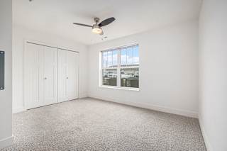 Bedroom with a ceiling fan and large windows  at Signature Pointe Apartment Homes, Athens, Alabama