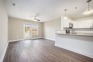 living room and kitchen with a door to a private patio  at Signature Pointe Apartment Homes, Alabama
