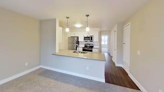 living room leading into a kitchen at Signature Pointe Apartment Homes in Athens, AL