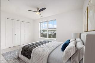 Spacious bedroom with ceiling fan and large window at Signature Pointe Apartment Homes in Athens, AL