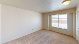 an empty bedroom with a large window at South Bridge Apartments, Indiana