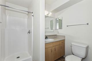 a bathroom with a shower toilet sink and mirror at Stoney Pointe Apartment Homes, Wichita