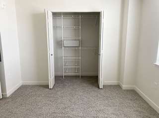 bedroom with a closet with organizers and plush carpeting at Stoney Pointe Apartment Homes, Kansas