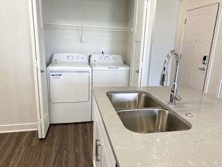 a kitchen with a sink and a washer and dryerat Stoney Pointe Apartment Homes, Kansas, 67226