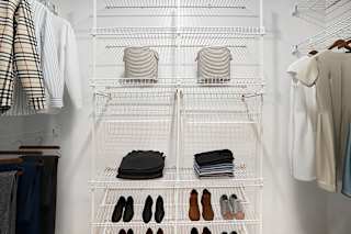 A walk-in closet with clothes and shoes organized on shelves at Stoney Pointe Apartment Homes, Wichita