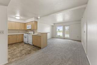 A kitchen with a breakfast bar, white dishwasher and stove top oven at Stoney Pointe Apartment Homes, Wichita