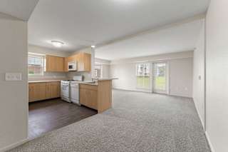 A kitchen with wooden cabinets and a white dishwasher at Stoney Pointe Apartment Homes, Kansas