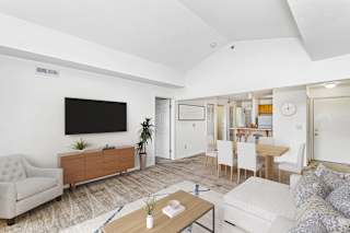 a living room with a high ceiling, couch and a dining table at Stoney Pointe Apartment Homes, Kansas