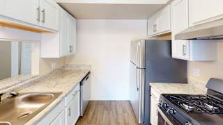 a kitchen with stainless steel appliances and white cabinets  at Swiss Valley Apartments, Wyoming, MI, 49509