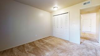 an empty bedroom with a closet and a doorat Swiss Valley Apartments in Wyoming, MI
