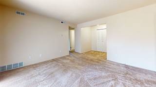 an empty living room with a door to a closet at Swiss Valley Apartments, Wyoming, MI