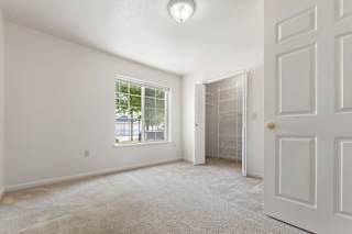 A bedroom with a large window, walk-in closet and carpet at Tall Oaks Apartment Homes, Kalamazoo, MI, 49009