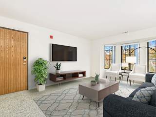 A living room with a bay window, a couch, and a rug  at Tanglewood Apartments, Oak Creek, WI