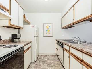 A galley style kitchen with a dishwasher  at Tanglewood Apartments, Oak Creek, WI