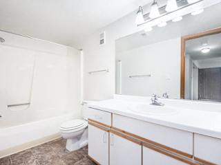 a bathroom with a bathtub/shower and a mirror at Tanglewood Apartments, Oak Creek, WI, 53154