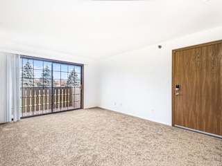 an empty living room with a slider to a balcony  at Tanglewood Apartments, Oak Creek, WI