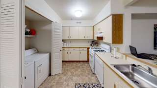 A kitchen with breakfast bar and washer/dryer at Tracy Creek Apartment Homes, Perrysburg, Ohio