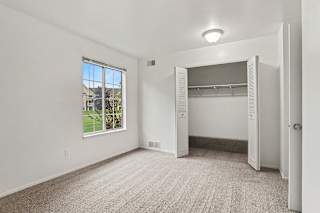 A spacious bedroom with a large window and a closet at Walnut Trail Apartments, Michigan