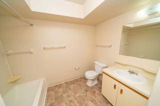 Spacious bathroom with a bathtub and shower at Windmill Lakes Apartments, Michigan