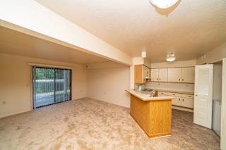 A living room with a slider to a private patio at Windmill Lakes Apartments, Holland, MI