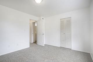 A white room with a carpeted floor and two doors.