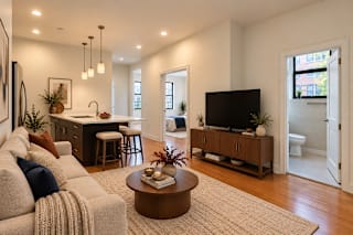 A living room with a couch, a coffee table, and a television.