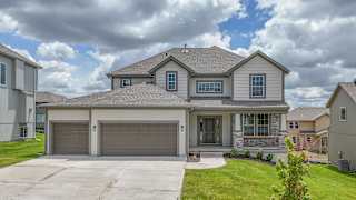 A house with a grey roof and a garage door.