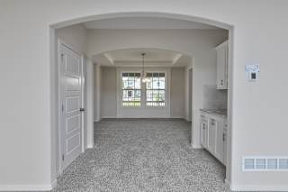 A spacious room with a carpeted floor and white walls.