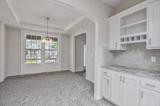 A kitchen with white cabinets and a marble countertop.