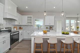 A kitchen with white cabinets and a marble countertop.
