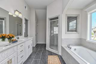A bathroom with a tub, sink, and mirror.